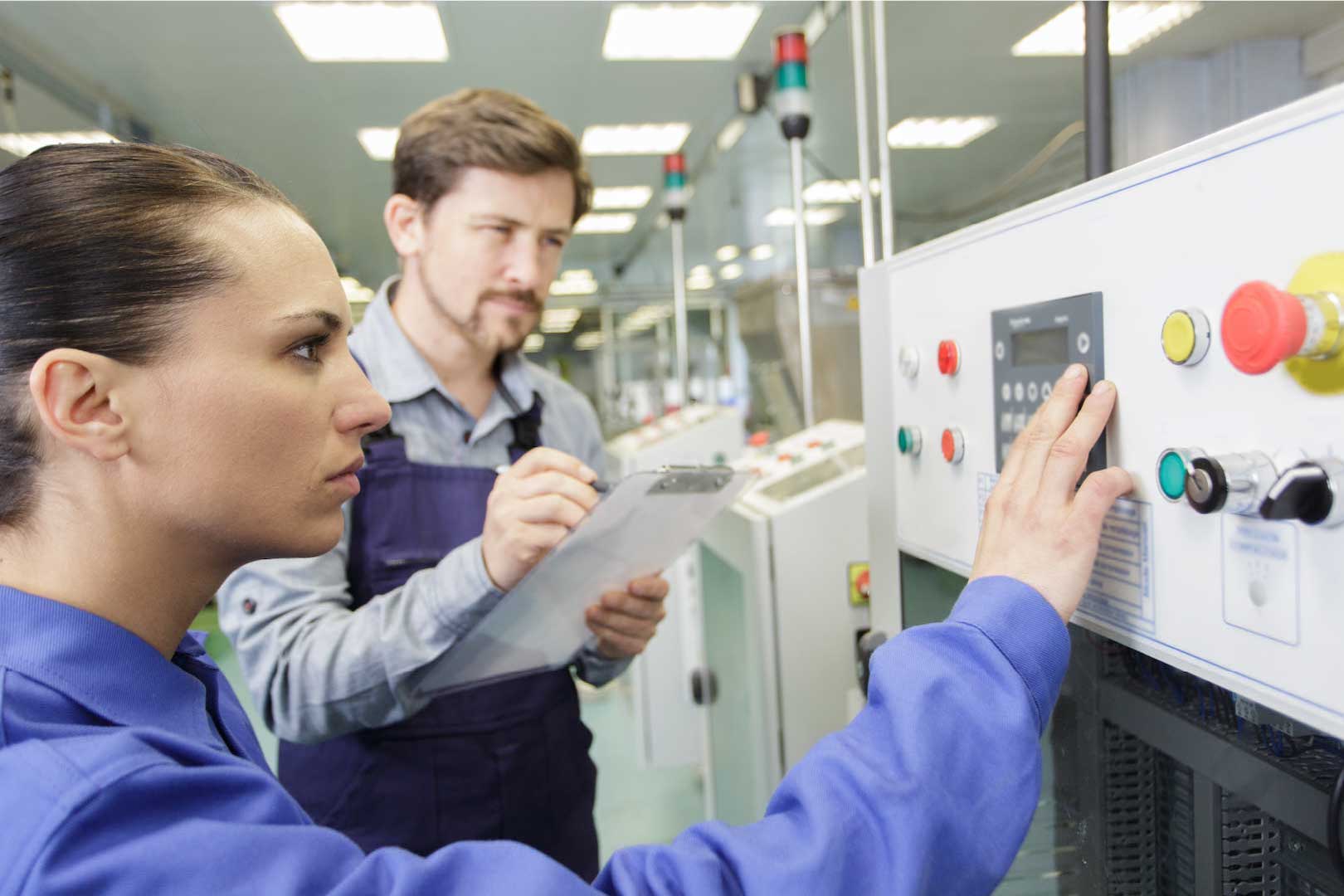 Workers at a machine on factory floor